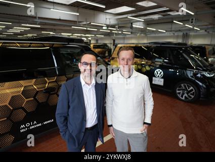 Hambourg, Allemagne. 18 novembre 2024. Sascha Meyer (R), directeur général de MoIA GmbH, et Christian Senger, membre du conseil d’administration des véhicules utilitaires Volkswagen pour AD MaaS/TaaS, se tiennent sur le hub de MoIA devant plusieurs ID de conduite autonome. Buzz AD de Volkswagen. Lors d'une conférence de presse, des informations ont été fournies sur l'état de la conduite autonome et les progrès réalisés à Hambourg. Crédit : Marcus Brandt/dpa/Alamy Live News Banque D'Images