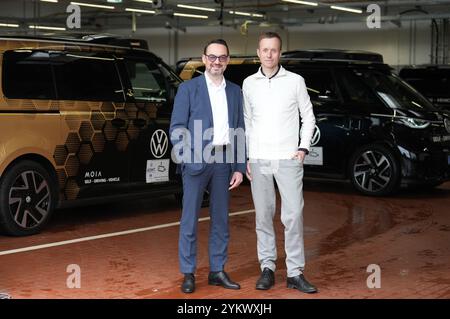 Hambourg, Allemagne. 18 novembre 2024. Sascha Meyer (R), directeur général de MoIA GmbH, et Christian Senger, membre du conseil d’administration des véhicules utilitaires Volkswagen pour AD MaaS/TaaS, se tiennent sur le hub de MoIA devant plusieurs ID de conduite autonome. Buzz AD de Volkswagen. Lors d'une conférence de presse, des informations ont été fournies sur l'état de la conduite autonome et les progrès réalisés à Hambourg. Crédit : Marcus Brandt/dpa/Alamy Live News Banque D'Images