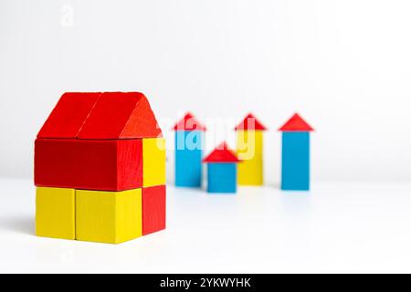 Maisons faites de blocs multicolores en bois sur un fond blanc Banque D'Images