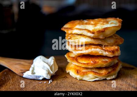 Crêpes sur une planche de bois avec de la crème sure. Banque D'Images