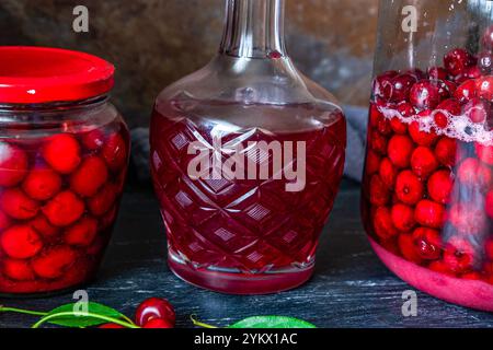 Conserves de cerises faites maison dans un bocal en verre et cerises rouges fraîchement dénoyautées conservées dans du sirop de sucre. Nourriture biologique en conserve du jardin. Banque D'Images