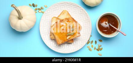 Toasts avec de la confiture de citrouille douce sur l'assiette sur fond bleu clair, vue de dessus Banque D'Images