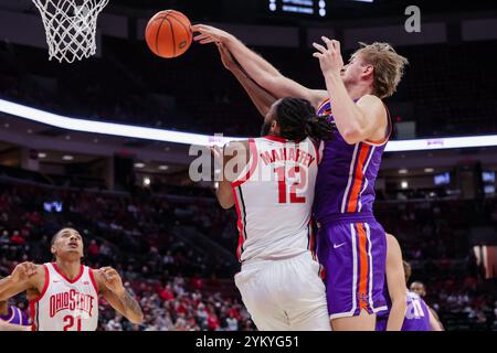 Columbus, Ohio, États-Unis. 19 novembre 2024. Le garde des Buckeyes de l'Ohio State Evan Mahaffey (12 ans) est attaqué par derrière par le centre des Purple Aces d'Evansville Michael Day (33 ans) sur un tir sous le panier pendant le match entre les Purple Aces d'Evansville et les Buckeyes de l'Ohio State à Value City Arena, Columbus, Ohio. (Crédit image : © Scott Stuart/ZUMA Press Wire) USAGE ÉDITORIAL SEULEMENT! Non destiné à UN USAGE commercial ! Banque D'Images