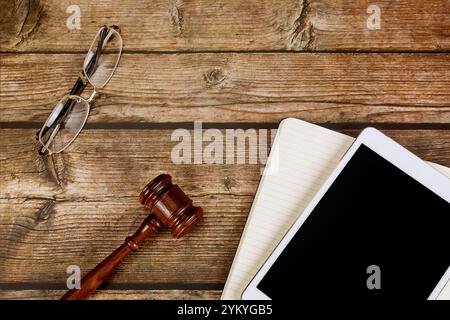 Juge Gavel repose sur le bureau en bois longues lunettes latérales, tablette numérique PC, représentant l'intersection de la technologie juridique dans l'environnement professionnel. Banque D'Images