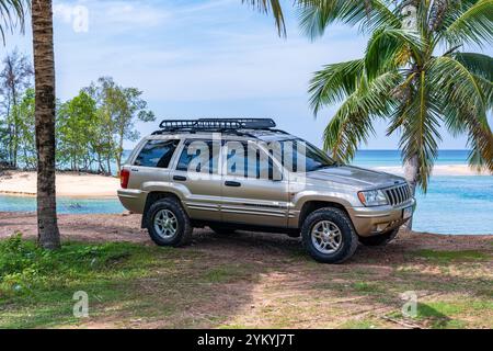 Phuket Thaïlande 19 novembre 2024 : Brown American SUV Jeep Grand Cherokee WJ 2002 près de la mer à Phuket Thaïlande, hors route sur terre, vue de la mer a Banque D'Images