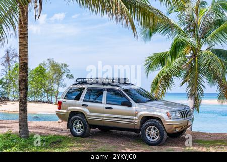 Phuket Thaïlande 19 novembre 2024 : Brown American SUV Jeep Grand Cherokee WJ 2002 près de la mer à Phuket Thaïlande, hors route sur terre, vue de la mer a Banque D'Images