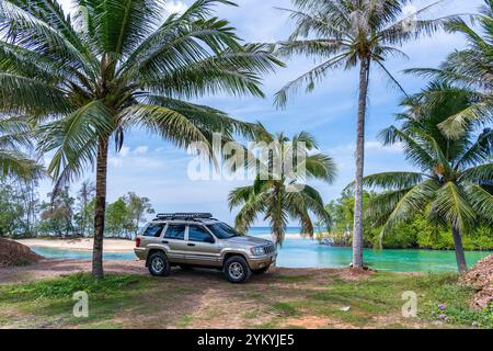 Phuket Thaïlande 19 novembre 2024 : Brown American SUV Jeep Grand Cherokee WJ 2002 près de la mer à Phuket Thaïlande, hors route sur terre, vue de la mer a Banque D'Images