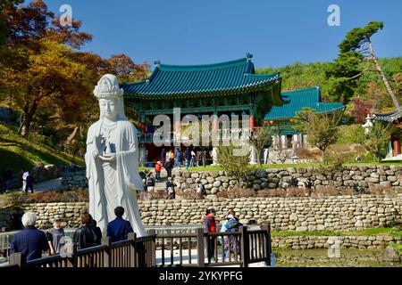 Comté de Yangyang, Corée du Sud - 3 novembre 2024 : la statue d'Avalokitesvara avec la toile de fond pittoresque des pavillons traditionnels des temples coréens à Naksan Banque D'Images
