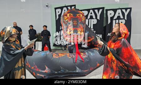 Bakou, Azerbaïdjan. 20 novembre 2024. Des militants font la queue lors d’une manifestation au sommet de l’ONU sur le climat COP29, représentant les nombreux lobbyistes du charbon, du pétrole et du gaz présents à la conférence. Crédit : Larissa Schwedes/dpa/Alamy Live News Banque D'Images