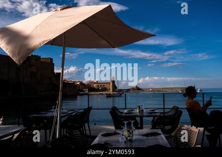 Terrasse d'un restaurant d'un paysage marin de la ville de Collioure avec le château royal et le phare de l'église notre-Dame-des-Anges sur la Côte Banque D'Images