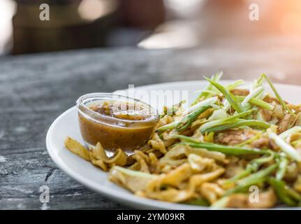 nouilles avec des oignons verts et de la saucisse sur une assiette Banque D'Images