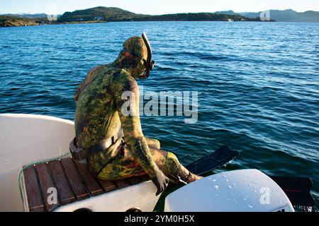 Plongeur en combinaison de plongée scaphandre sautant d'un bateau pour Snorkel - Norway Vacations Banque D'Images