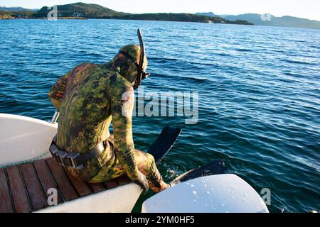 Plongeur en combinaison de plongée scaphandre sautant d'un bateau pour Snorkel - Norway Vacations Banque D'Images