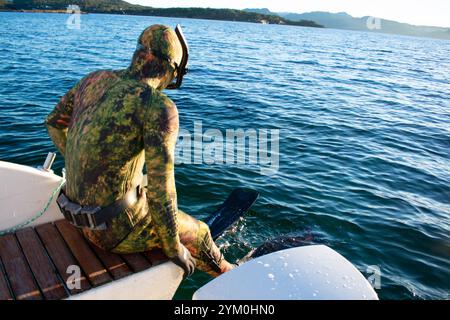 Plongeur en combinaison de plongée scaphandre sautant d'un bateau pour Snorkel - Norway Vacations Banque D'Images