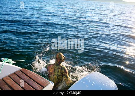 Plongeur en combinaison de plongée scaphandre sautant d'un bateau pour Snorkel - Norway Vacations Banque D'Images