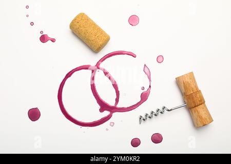 Tire-bouchon, liège et taches de vin rouge sur fond blanc, vue de dessus Banque D'Images