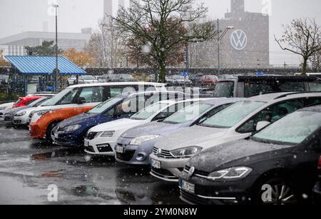 Wolfsburg, Allemagne. 20 novembre 2024. Les voitures sont à portée de vue de la centrale de cogénération de chaleur et d'électricité sur le terrain de l'usine Volkswagen de Wolfsburg. IG Metall et le comité d'entreprise général de Volkswagen ont présenté les points clés d'un concept global pour Volkswagen. Crédit : Julian Stratenschulte/dpa/Alamy Live News Banque D'Images