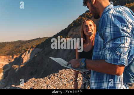 Groupe de quatre amis randonnant à travers la campagne ensemble au coucher du soleil. Banque D'Images