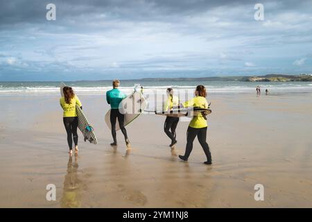 Un instructeur de surf de l'Escape Surf School avec ses apprenants novices de surf au début d'une leçon de surf sur Towan Beach à Newquay à Cornw Banque D'Images