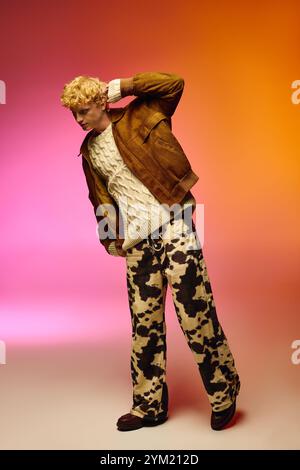 Un homme élégant met en valeur les tendances de la mode de vacances avec un pull en maille confortable et une veste en cuir marron. Il l'associe avec un pantalon à motifs unique, créant Banque D'Images