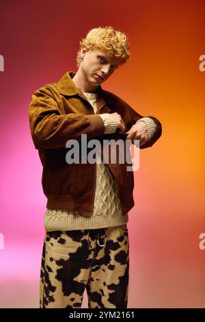 Un jeune homme présente une tenue de vacances tendance avec un pull confortable et une veste élégante, festivités. Des couleurs de fond éclatantes améliorent la fête Banque D'Images