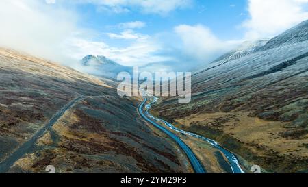 Large estuaire entre les collines en Islande, rivière gelée sinueuse, route asphaltée. Paysage touristique pittoresque Banque D'Images