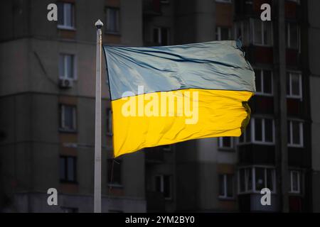 Kiev, ville de Kiev, Ukraine. 20 novembre 2024. Drapeau ukrainien vu à Kiev devant un immeuble résidentiel de grande hauteur. Alors que le drapeau ukrainien est clair par la lumière du soleil, de nombreux appartements restent sombres en raison des coupures de courant introduites après que la Russie a attaqué des infrastructures critiques dans toute l'Ukraine. (Crédit image : © Andreas Stroh/ZUMA Press Wire) USAGE ÉDITORIAL SEULEMENT! Non destiné à UN USAGE commercial ! Banque D'Images