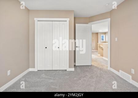 Une chambre blanche avec un placard blanc et une porte blanche. La chambre est vide et a un look épuré et minimaliste Banque D'Images