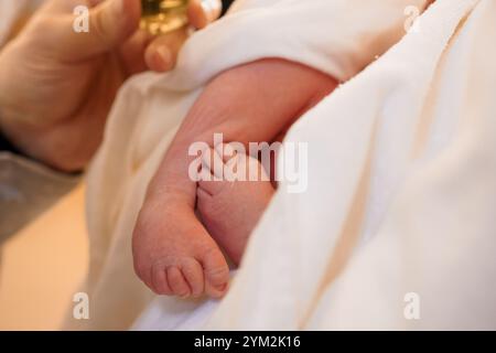 Moment tendre : pieds du nouveau-né bercés dans un tissu doux. Banque D'Images