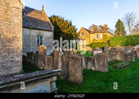 Lumière du soir sur le vieux presbytère vu depuis le cimetière de l'église Saint-Jean-Baptiste dans le village Cotswold de Great Rissington, Gloucestershire Banque D'Images