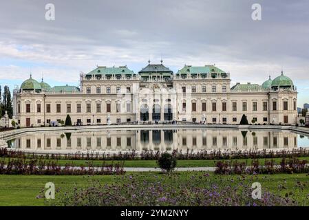 Un palais baroque symétrique reflétant dans un étang, entouré de jardins sous un ciel couvert. Vienne, Autriche, Europe Banque D'Images