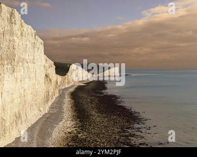 Spectaculaire coucher de soleil vue sur les falaises blanches et une plage de galets le long de la mer. Douvres, Angleterre, Royaume-Uni, Europe Banque D'Images