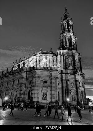 Image en noir et blanc d'une cathédrale la nuit, avec des lampadaires éclairant les gens marchant à proximité, scène de nuit en noir et blanc d'une église avec dra Banque D'Images