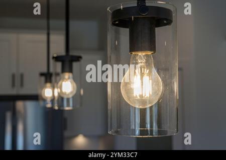 Un luminaire avec trois ampoules est allumé. La lumière est chaleureuse et accueillante, créant une atmosphère chaleureuse Banque D'Images
