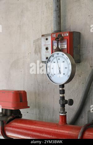 Manomètres ou manomètre de pression montés sur le pipeline et système D'ALARME INCENDIE DE signal, tubes métalliques fixés sur le mur. Banque D'Images