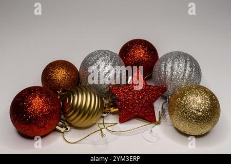 Boules de noël multicolores avec une étoile rouge isolée sur un fond lumineux Banque D'Images