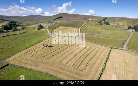 Agriculteur qui reçoit de l'ensilage avec un wagon à fourrage, sur une ferme de colline près de Hawes dans les Yorkshire Dales, Royaume-Uni. Banque D'Images