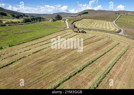 Agriculteur qui reçoit de l'ensilage avec un wagon à fourrage, sur une ferme de colline près de Hawes dans les Yorkshire Dales, Royaume-Uni. Banque D'Images