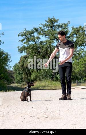 jeune garçon donnant des ordres à son chien Banque D'Images