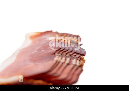 Gros plan d'un morceau de bacon avec un fond blanc. Le bacon est tranché en fines lamelles et il est très frais Bacon isolé sur fond blanc. Banque D'Images