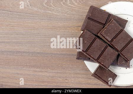 Gros plan sur une barre de chocolat cassée sur le bord du plat. Banque D'Images