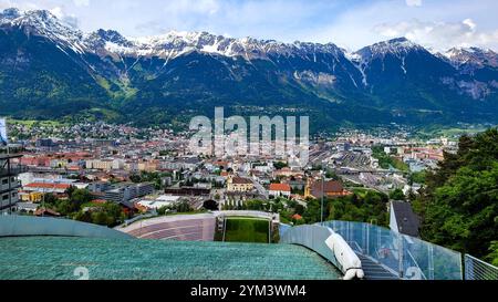 Une vue panoramique de dessus passionnante du stade de saut à ski de Bergisel à Innsbruck. En arrière-plan - Alpes majestueuses avec des sommets enneigés. 19 mai Banque D'Images