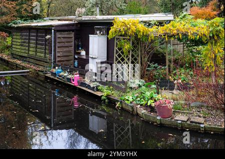 Hangar de jardin reflétant dans le canal dans les jardins publics de lotissement à Amsterdam, pays-Bas, 14 novembre 2024 Banque D'Images