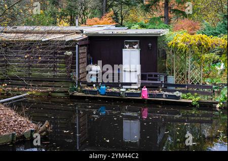 Hangar de jardin reflétant dans le canal dans les jardins publics de lotissement à Amsterdam, pays-Bas, 14 novembre 2024 Banque D'Images