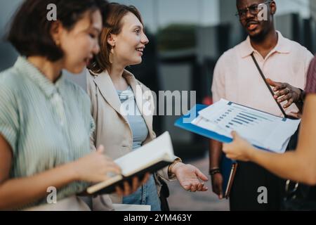 Professionnels multiculturels engagés dans une réunion en plein air animée Banque D'Images