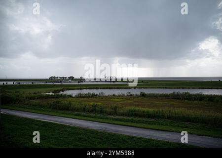 Une vue du lac Okeechobee depuis Port Mayaka alors qu'une tempête se profile en arrière-plan. Port Mayaca Lock and Dam, situé sur le côté est du lac Okeechobee à la jonction avec le canal Lucie. La voie navigable Okeechobee s'étend jusqu'au golfe du Mexique en empruntant la rivière Caloosahatchee et jusqu'à l'océan Atlantique en empruntant le canal Lucie. Couvrant 152 milles, la voie navigable sert de lien commercial et récréatif. Le corps des ingénieurs a construit et gère actuellement cinq écluses le long de la voie navigable. L'écluse de Port Mayaca a été construite en 1977 à des fins de navigation, pour permettre le raisi Banque D'Images