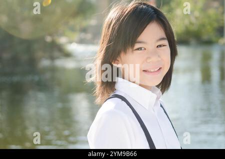 Fille de l'école primaire riant dans la lumière Banque D'Images