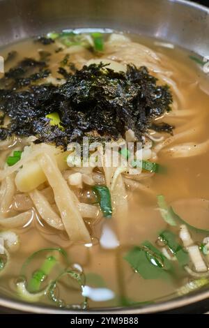 Un bol de kalguksu, nouilles coréennes coupées au couteau dans un bouillon salé Banque D'Images