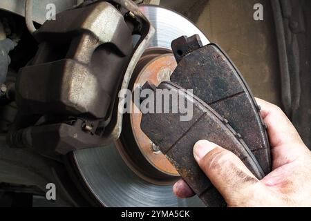 Les mécaniciens automatiques remplacent les plaquettes de frein usées pour maintenir un système de freinage de voiture, concept d'entretien de voiture Banque D'Images