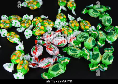 Nourriture, friandises, vacances, fêtes. Beaux bonbons aux fruits fabriqués à partir de jus et d'extrait de fruits emballés dans du polyéthylène coloré et brillant. Banque D'Images